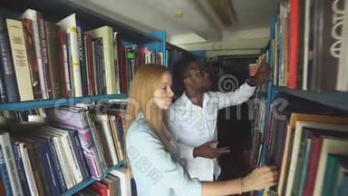 两名年轻的白种人女学生在图书馆选书
